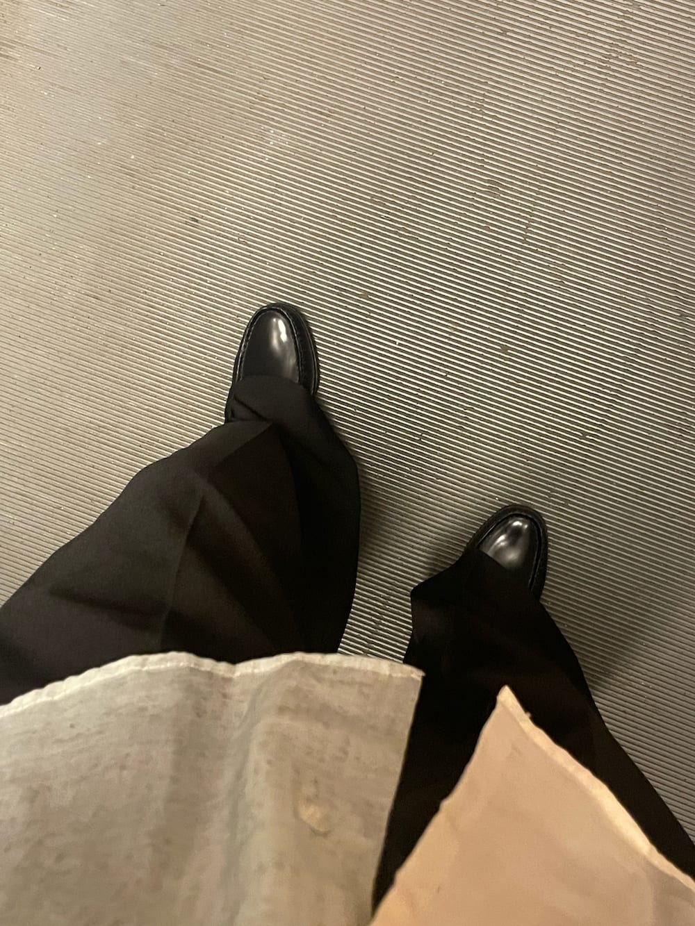 ブラック系のローファー、ベージュ系のシャツ/ブラウス、ブラック系のハンドバッグを着用したレディースの夏コーディネートの2枚目の写真