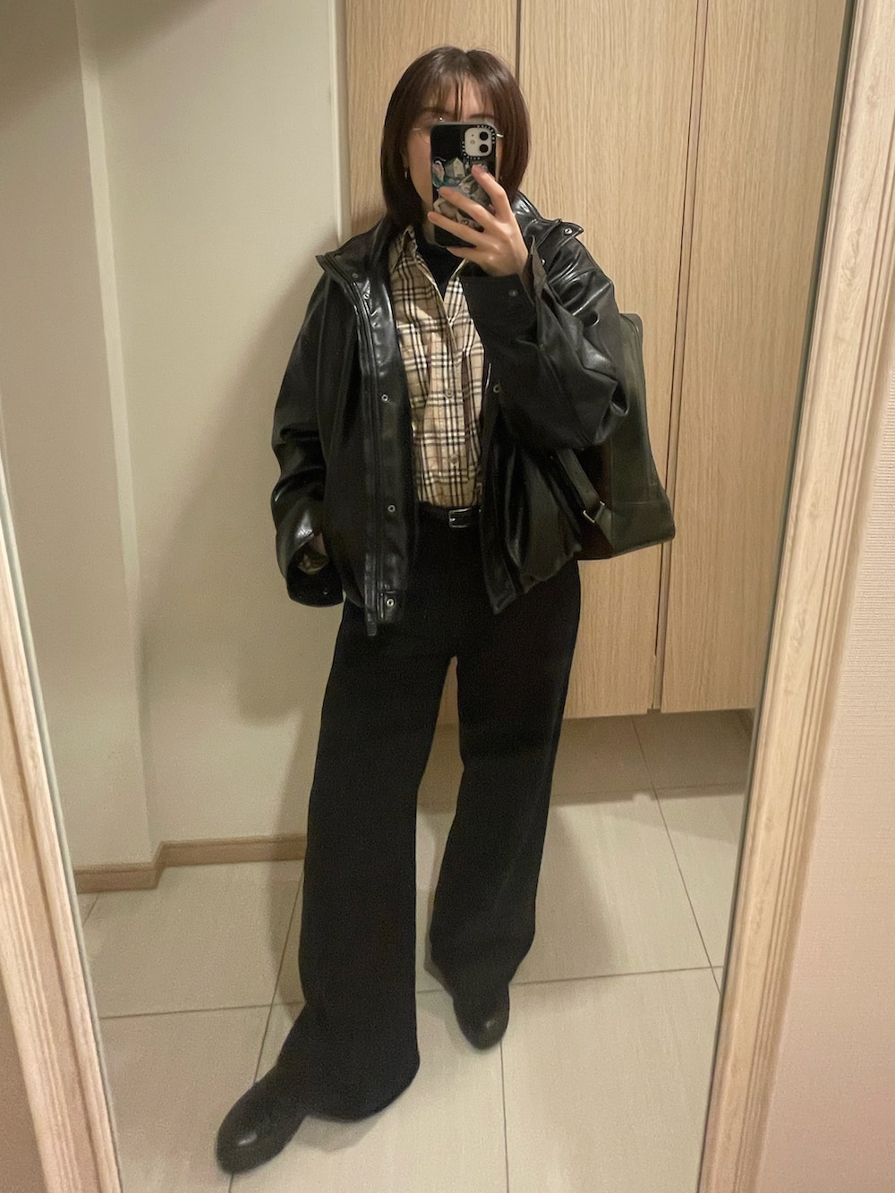 ベージュ系のシャツ/ブラウス、ブラック系のブルゾン、ブラック系のパンツを着用したレディースの秋コーディネートの2枚目の写真