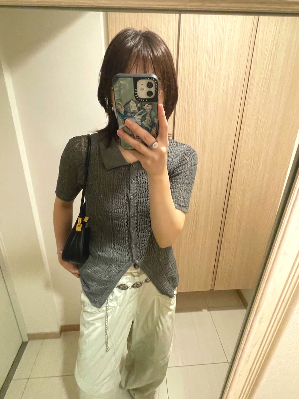 グレー系のニット/セーター、ホワイト系のカーゴパンツ、ブラック系のハンドバッグを着用したレディースの秋コーディネートの3枚目の写真