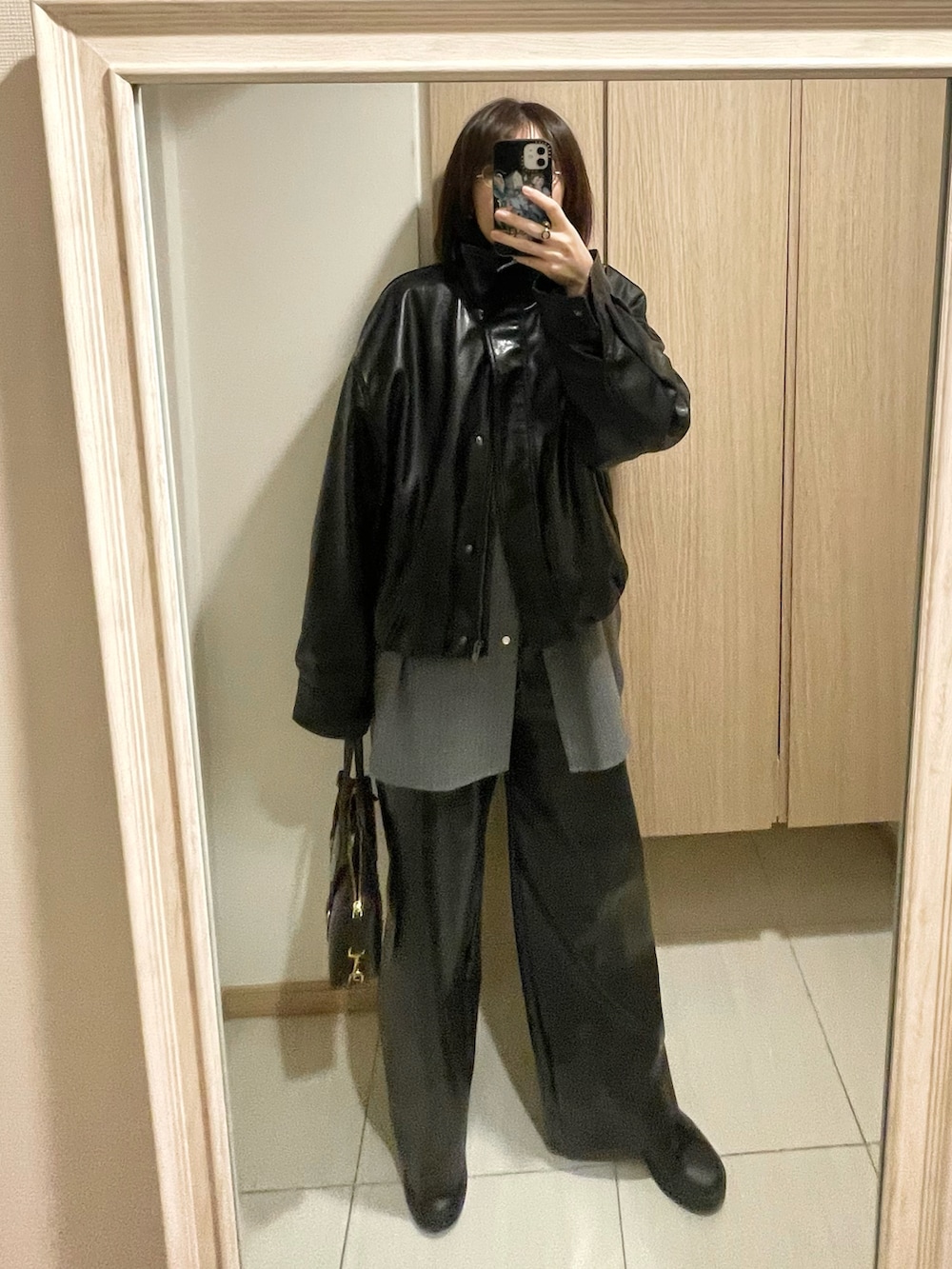 ブラック系のブルゾン、グレー系のシャツ/ブラウス、ブラック系のパンツを着用したレディースの秋コーディネートの2枚目の写真