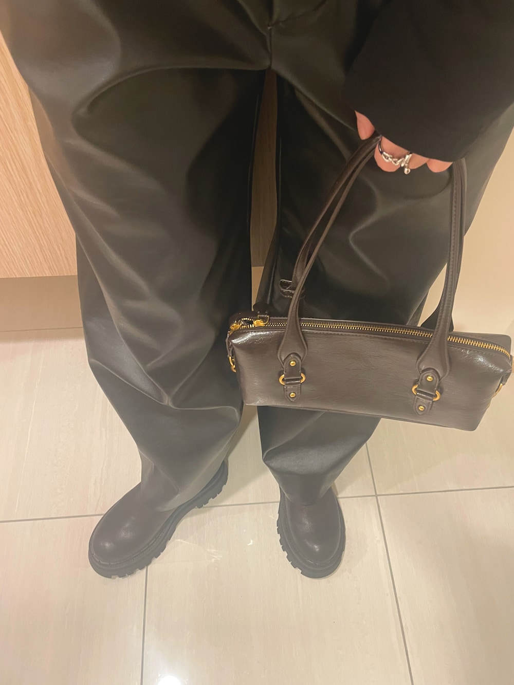 ブラック系のTシャツ/カットソー、ブラウン系のバッグ、ブラック系のパンツを着用したレディースの秋コーディネートの4枚目の写真