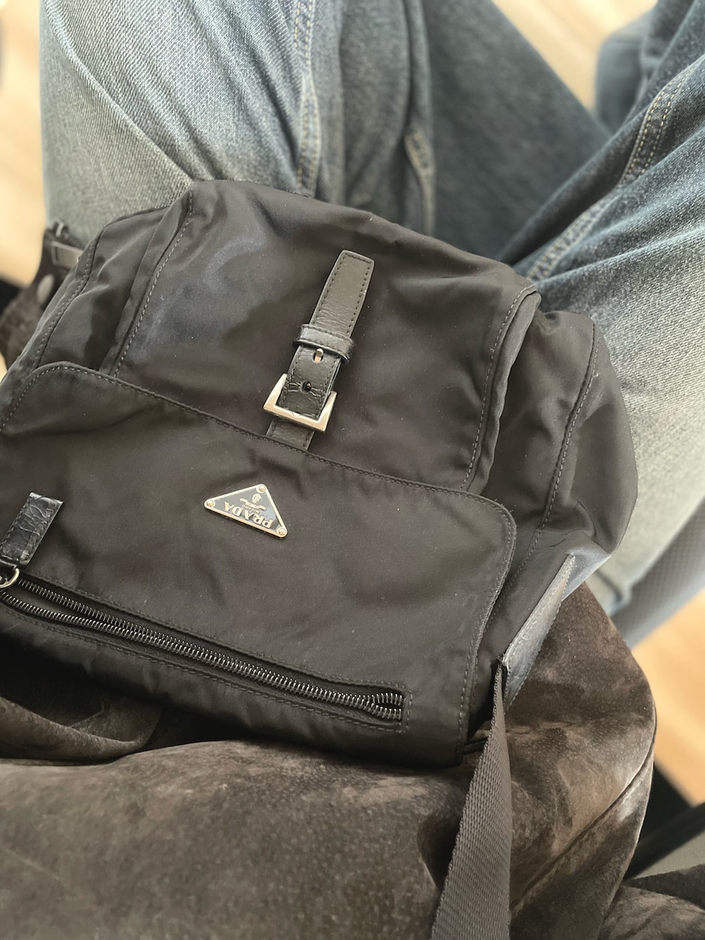 ブルー系のデニムパンツ、グレー系のカーディガン/ボレロ、ブラック系のバッグを着用したレディースの春コーディネートの2枚目の写真