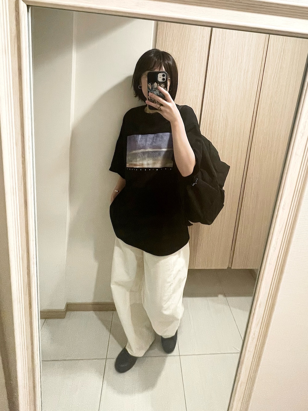 ブラック系のTシャツ/カットソー、ホワイト系のパンツ、ブラック系のスニーカーを着用したレディースの秋コーディネートの3枚目の写真