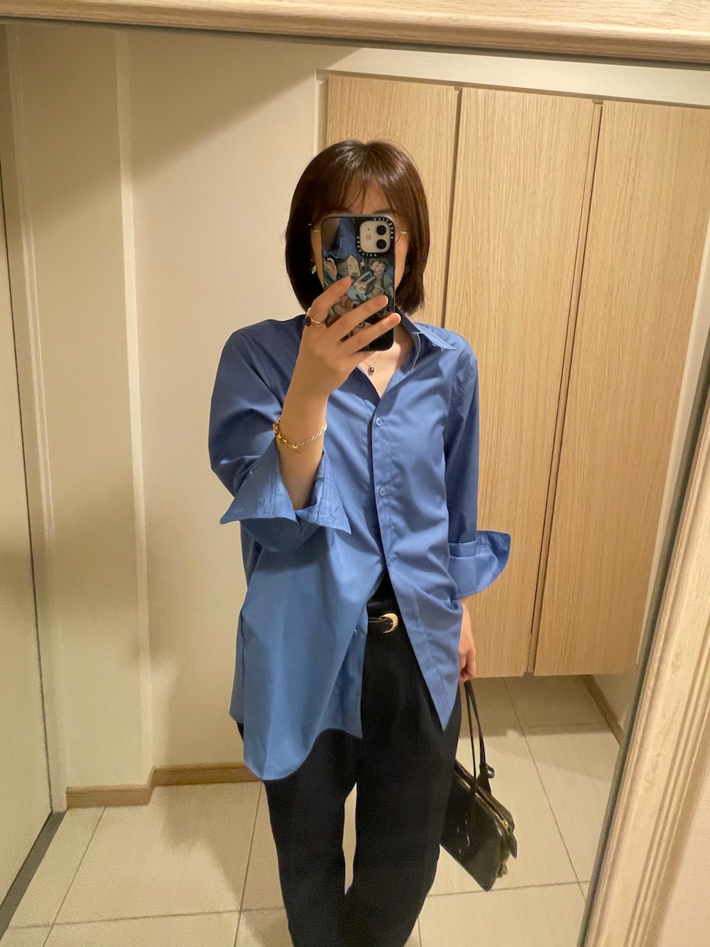 ブルー系のシャツ/ブラウス、ブルー系のパンツ、ブラウン系のバッグを着用したレディースの秋コーディネートの2枚目の写真