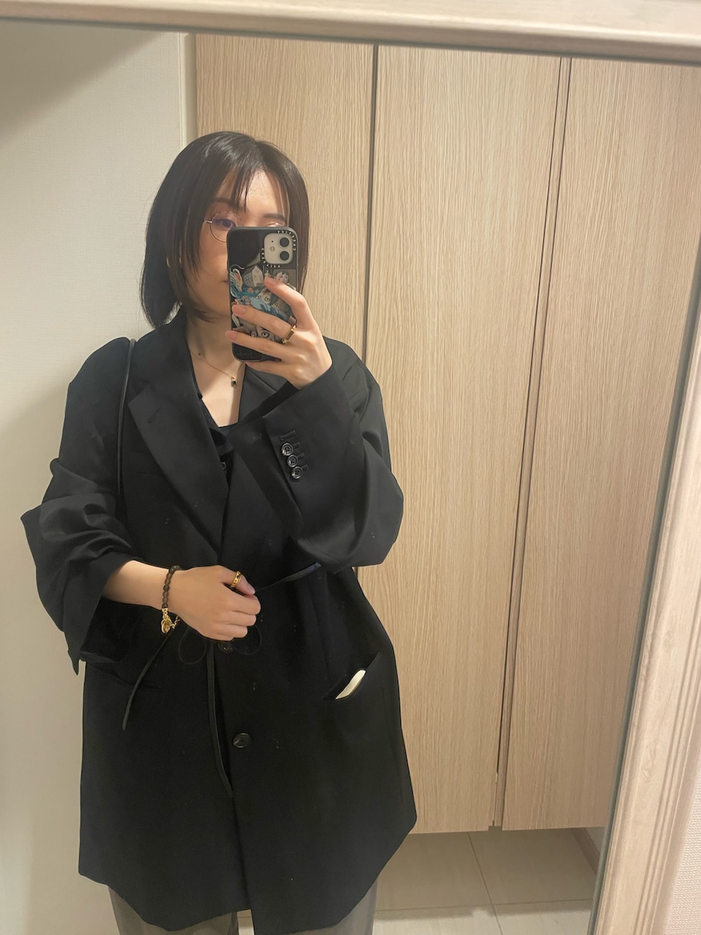 ブラック系のカーディガン/ボレロ、ブラック系のハンドバッグ、ブラック系のテーラードジャケットを着用したレディースの冬コーディネートの2枚目の写真