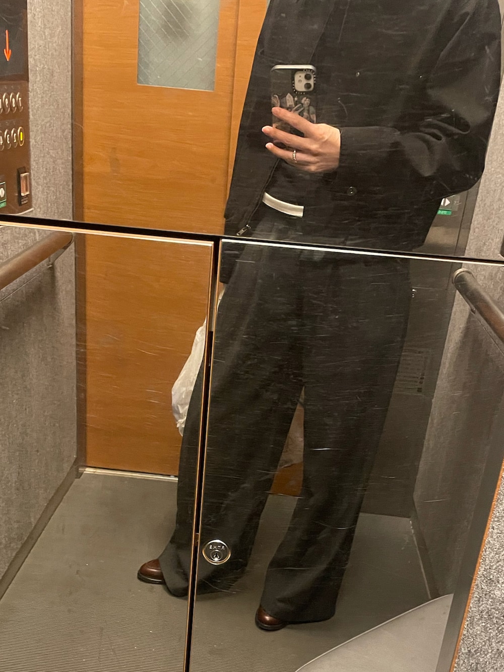 ブラウン系のローファー、ブラック系のトップス、グレー系のパンツを着用したレディースの春コーディネートの4枚目の写真