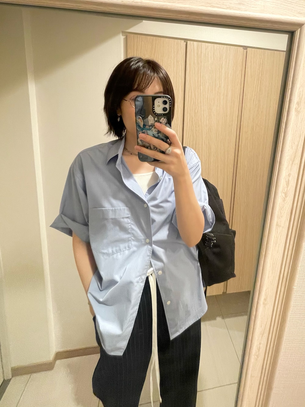 ブルー系のシャツ/ブラウス、ブルー系のスラックス、ホワイト系のスニーカーを着用したレディースの秋コーディネートの2枚目の写真