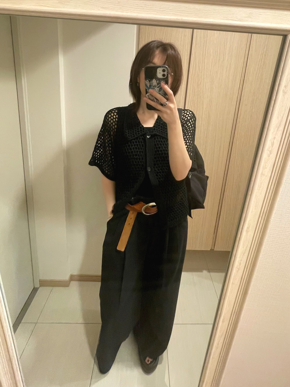 ブラック系のサンダル、ブラック系のシャツ/ブラウス、ブラック系のスラックスを着用したレディースの秋コーディネートの2枚目の写真