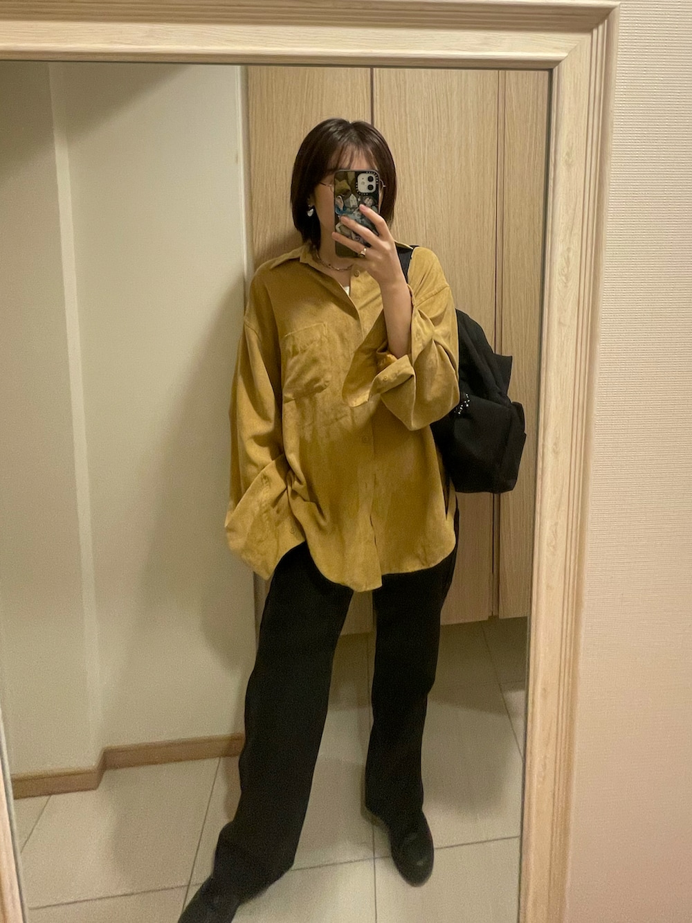 ベージュ系のシャツ/ブラウス、ブルー系のデニムパンツ、シルバー系のピアス（両耳用）を着用したレディースの秋コーディネートの3枚目の写真