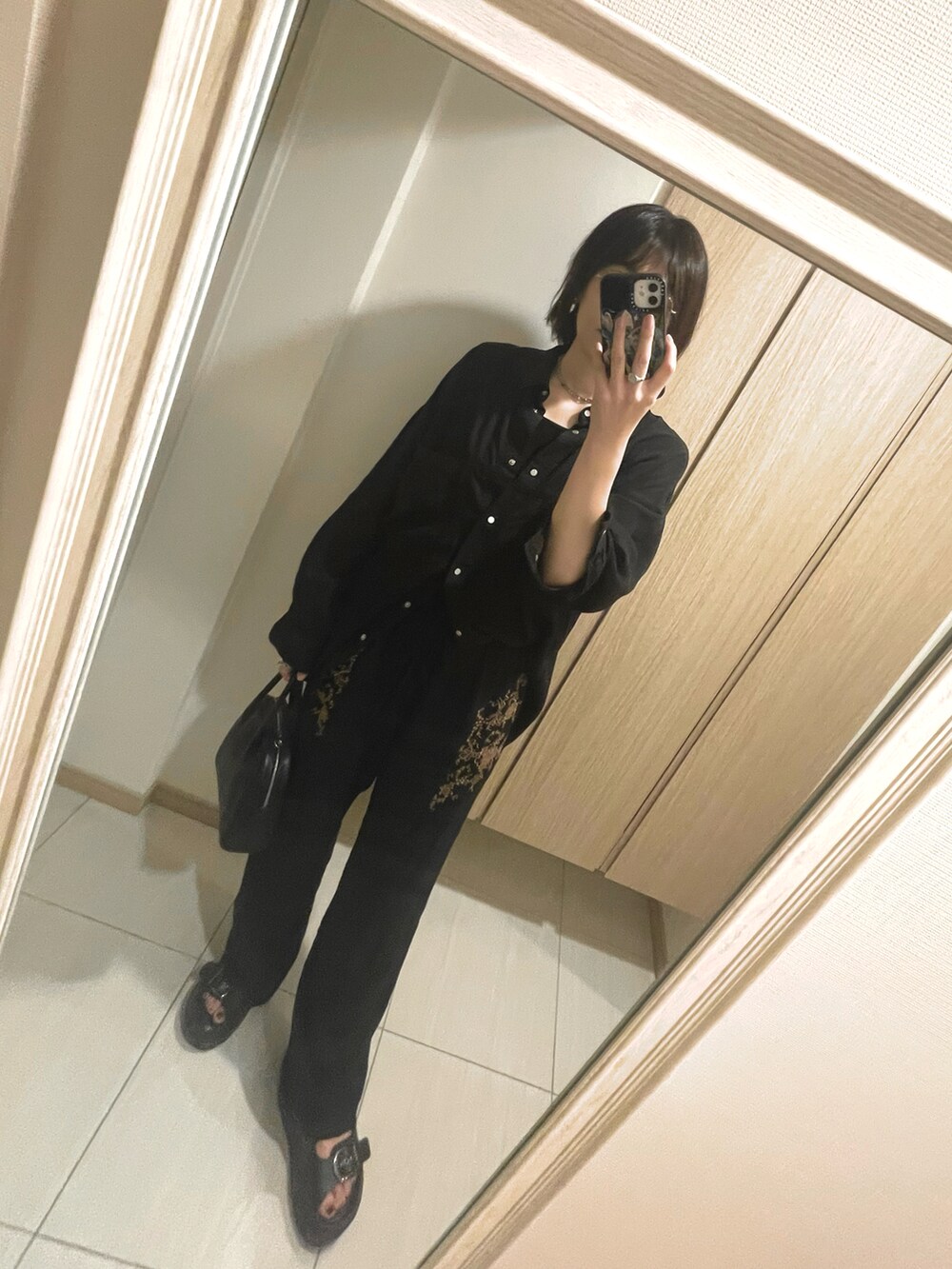 ブラック系のサンダル、ブラック系のシャツ/ブラウス、ブラック系のパンツを着用したレディースの秋コーディネートの3枚目の写真