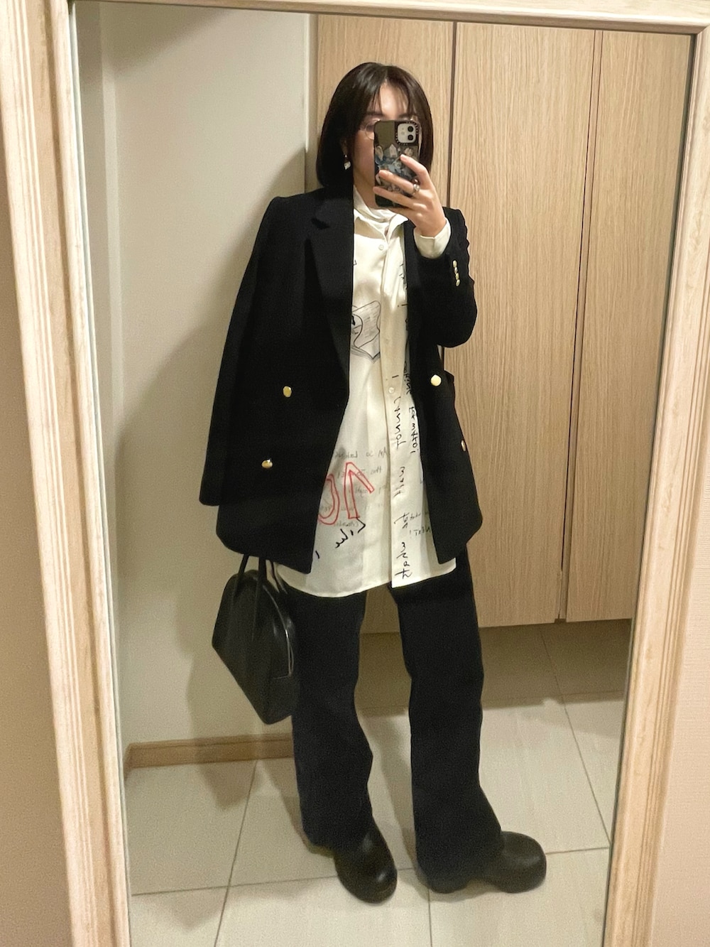 ブルー系のその他パンツ、ホワイト系のシャツ/ブラウス、ブラック系のハンドバッグを着用したレディースの秋コーディネートの2枚目の写真