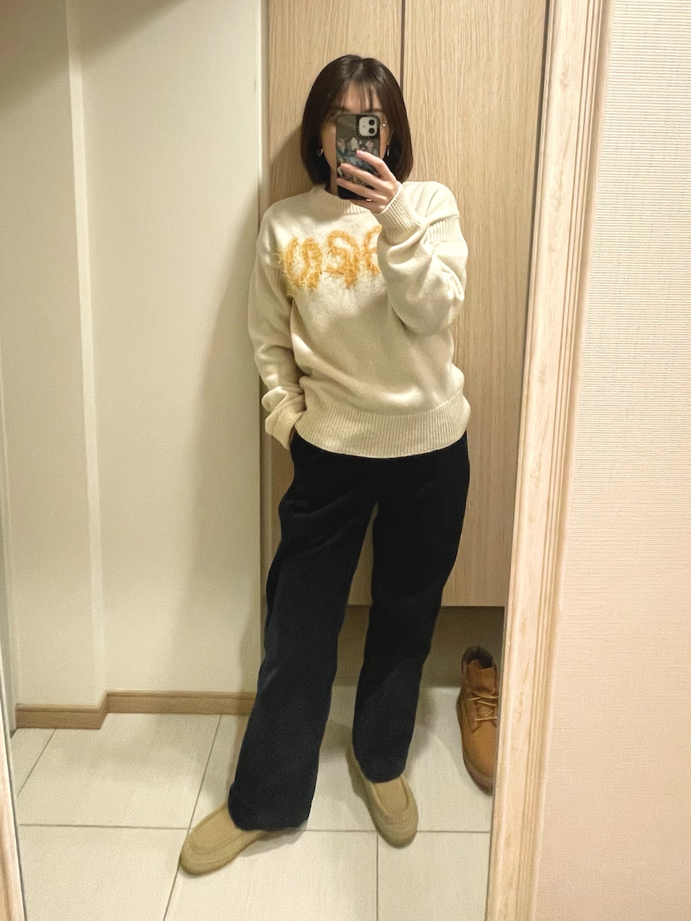 イエロー系のブーツ、ブルー系のその他パンツ、ベージュ系のニット/セーターを着用したレディースの冬コーディネートの2枚目の写真