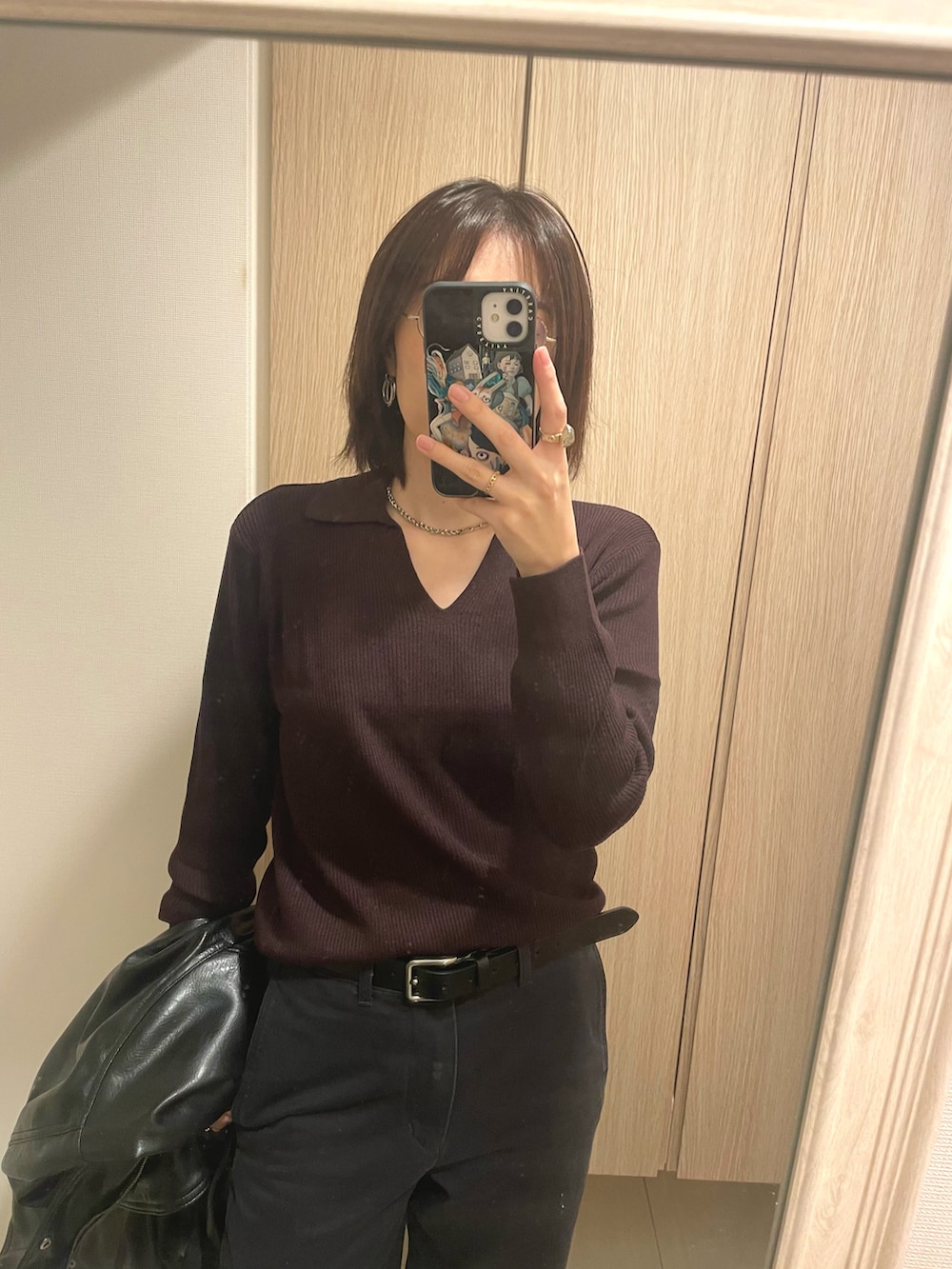 レッド系のトップス、グレー系のパンツ、ブラック系のシューズを着用したレディースの秋コーディネートの2枚目の写真