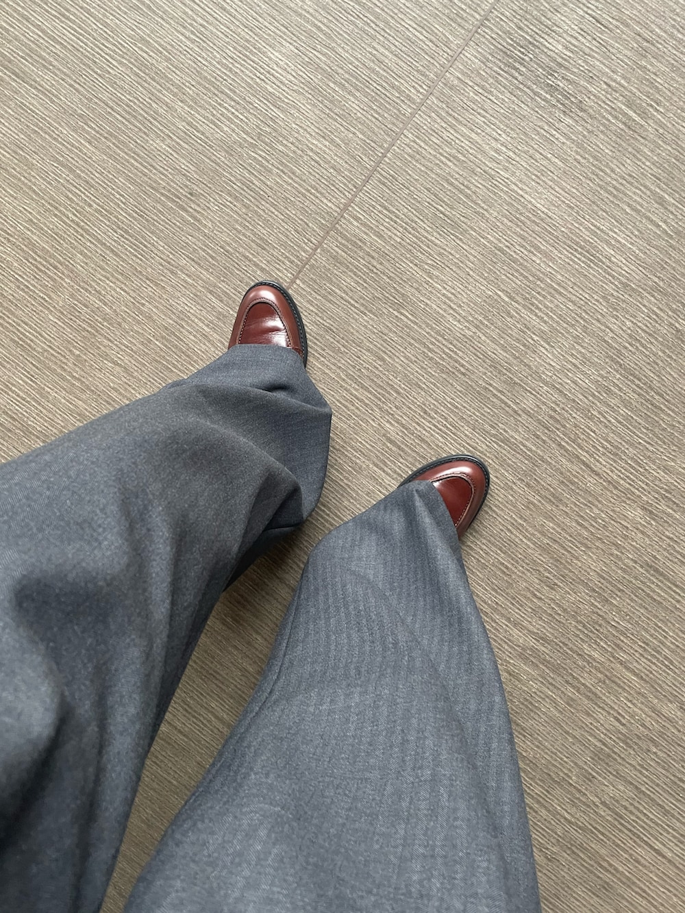 ブラウン系のローファー、ブラック系のトップス、グレー系のパンツを着用したレディースの春コーディネートの3枚目の写真