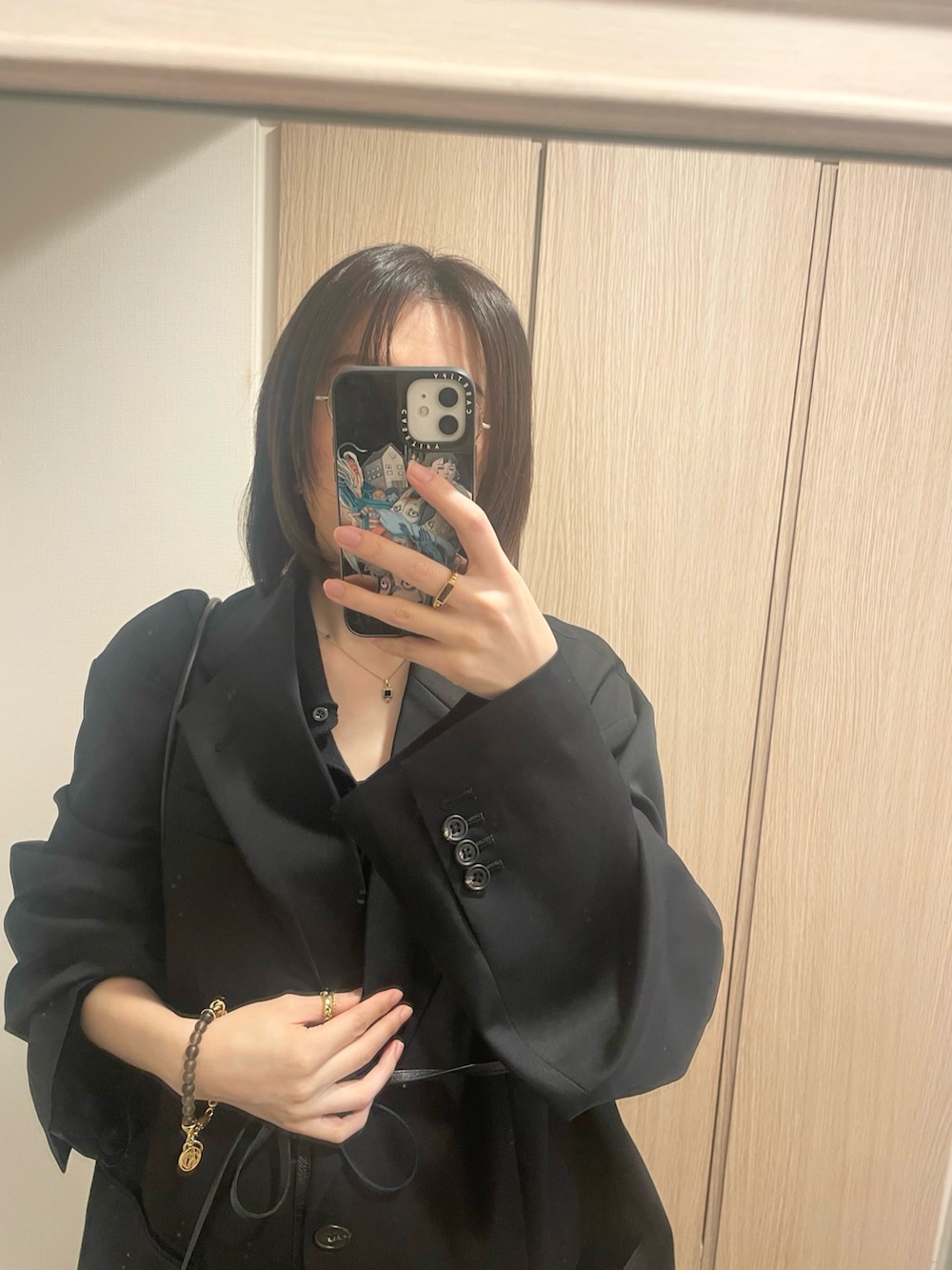 ブラック系のカーディガン/ボレロ、ブラック系のハンドバッグ、ブラック系のテーラードジャケットを着用したレディースの冬コーディネートの3枚目の写真