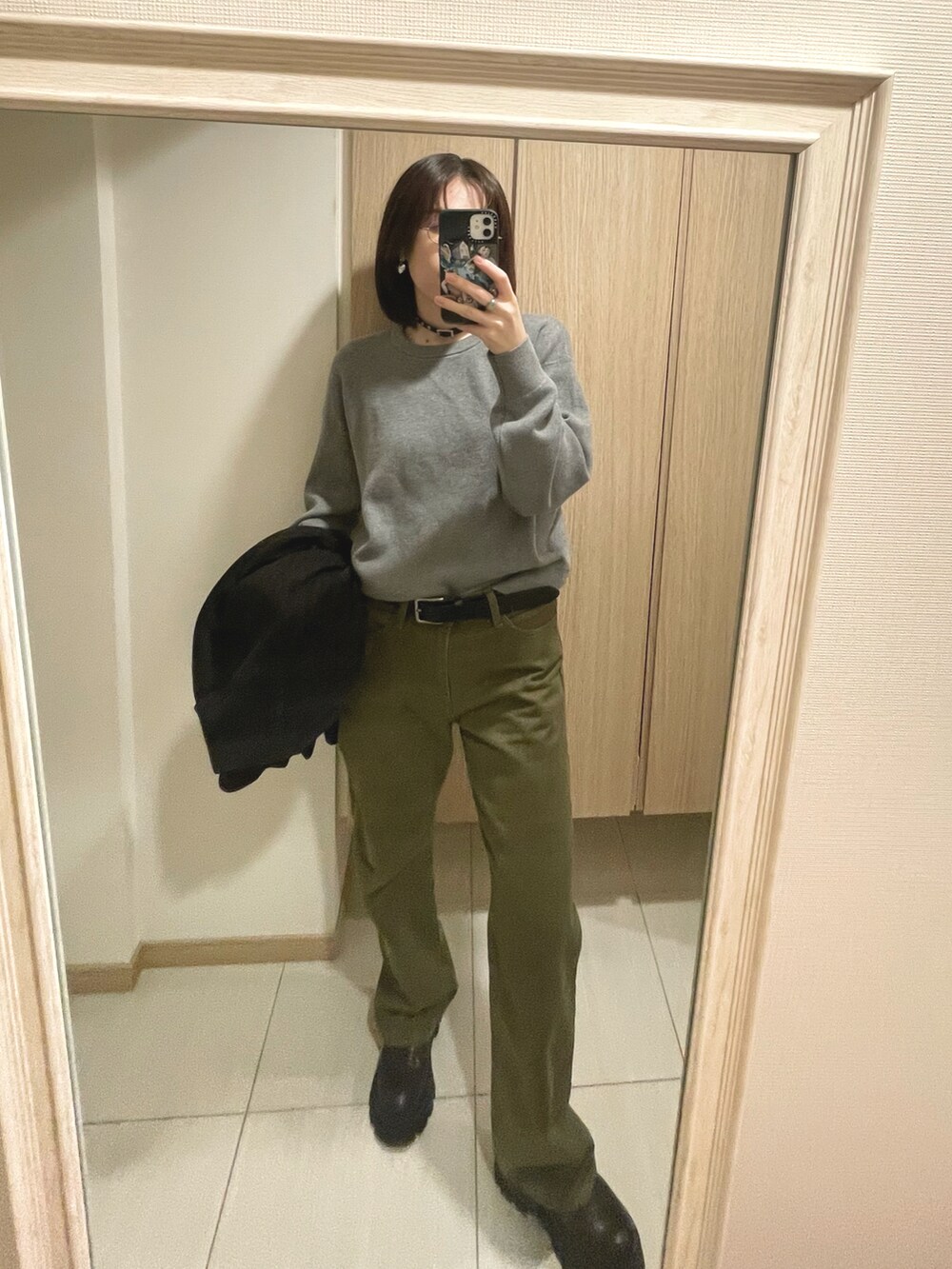 グレー系のトップス、ブラウン系のジャケット/アウター、グリーン系のパンツを着用したレディースの秋コーディネートの3枚目の写真