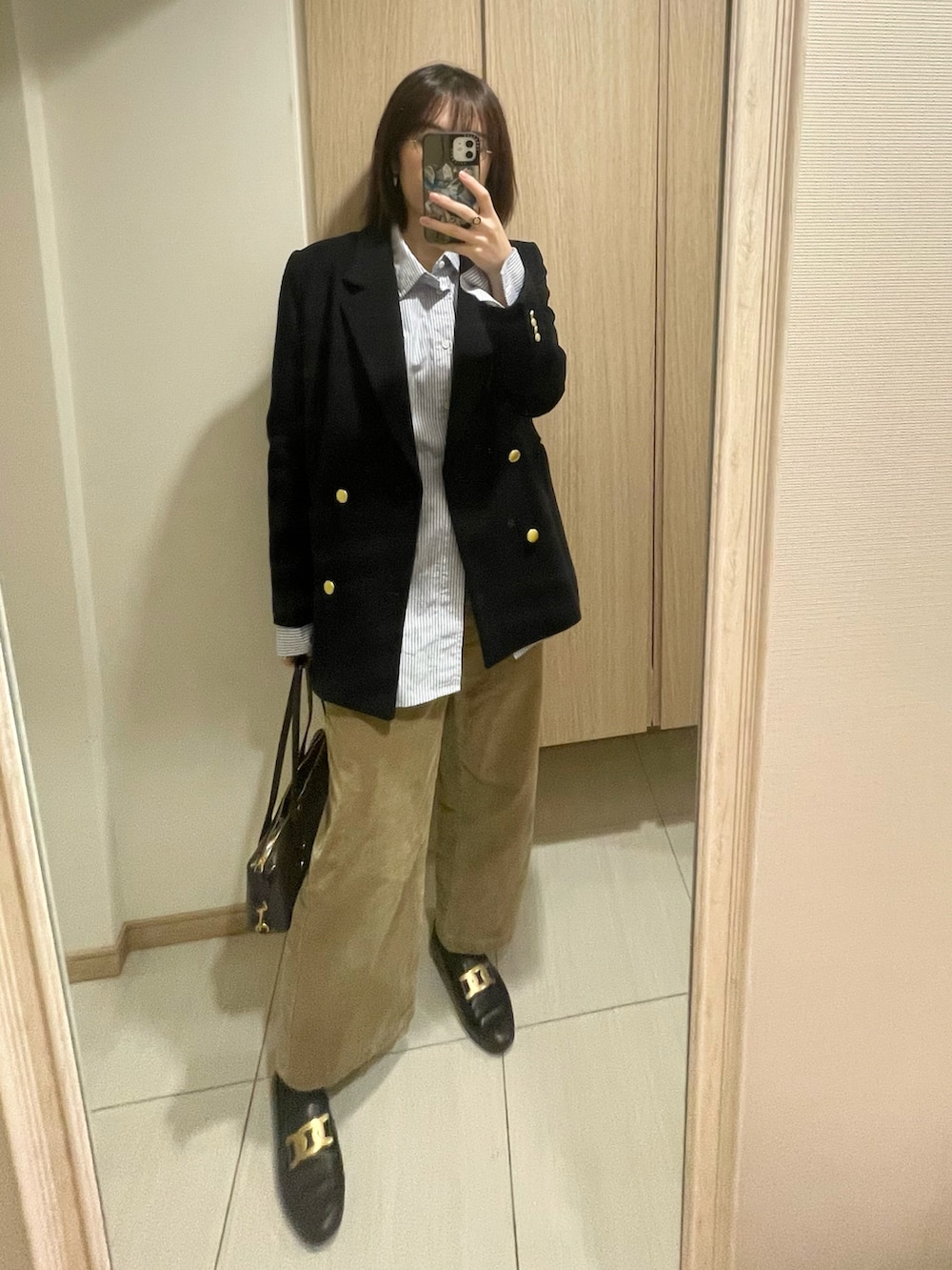 ホワイト系のシャツ/ブラウス、ベージュ系のその他パンツ、ブラック系のローファーを着用したレディースの秋コーディネートの2枚目の写真