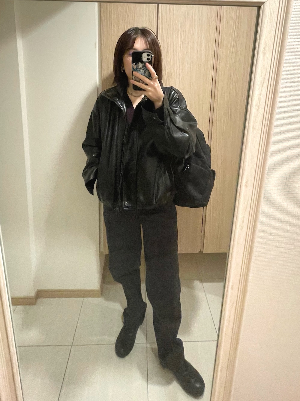 レッド系のトップス、グレー系のパンツ、ブラック系のシューズを着用したレディースの秋コーディネートの3枚目の写真