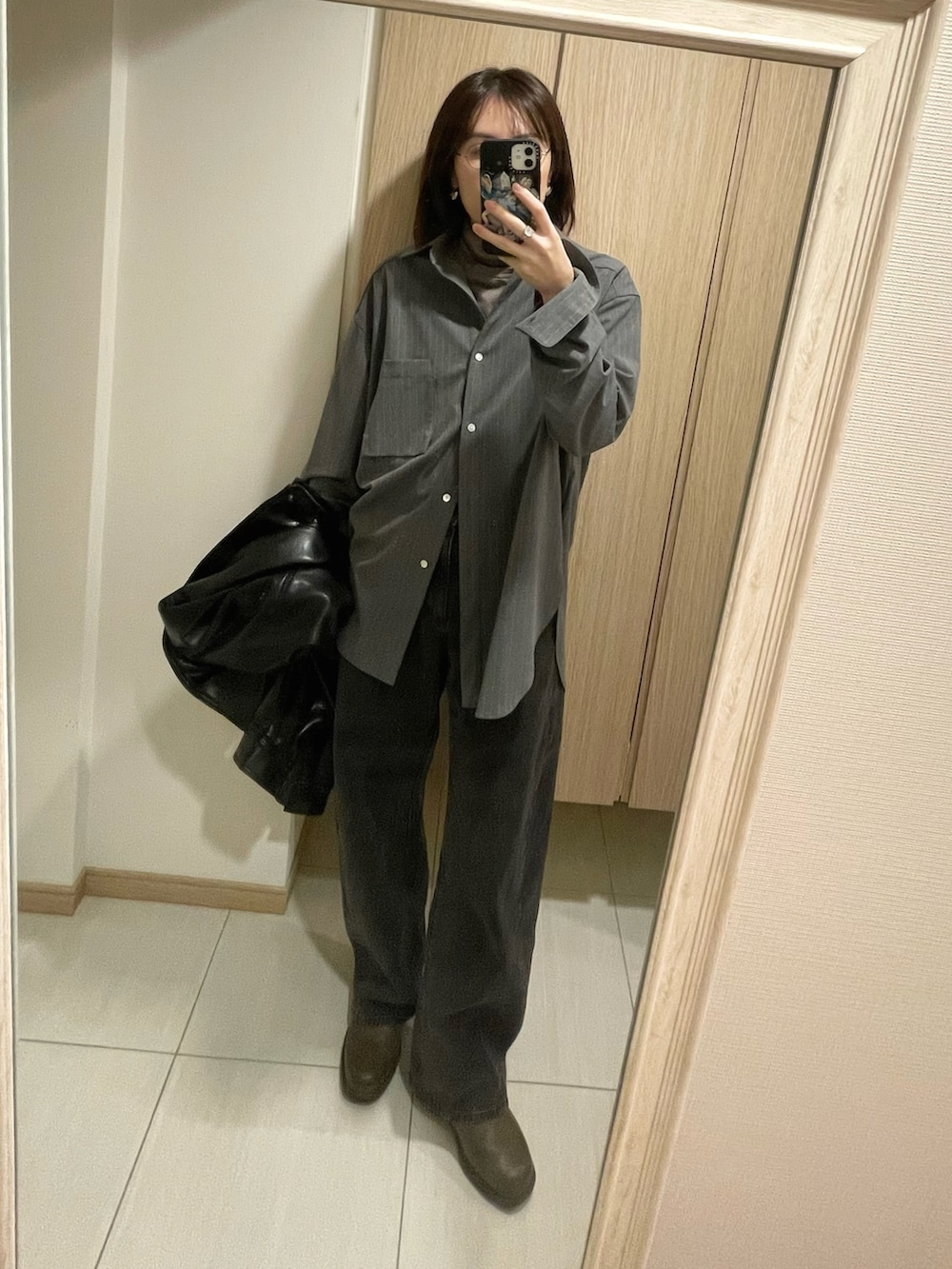 グレー系のシャツ/ブラウス、ベージュ系のTシャツ/カットソー、ブラック系のデニムパンツを着用したレディースの秋コーディネートの2枚目の写真