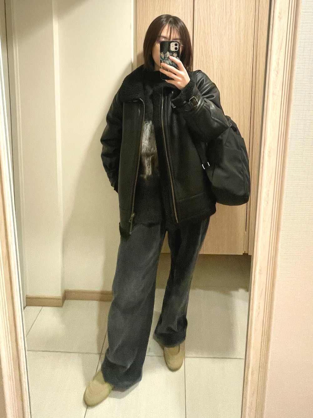 グレー系のニット/セーター、グレー系のスラックス、ベージュ系のスニーカーを着用したレディースの冬コーディネートの2枚目の写真