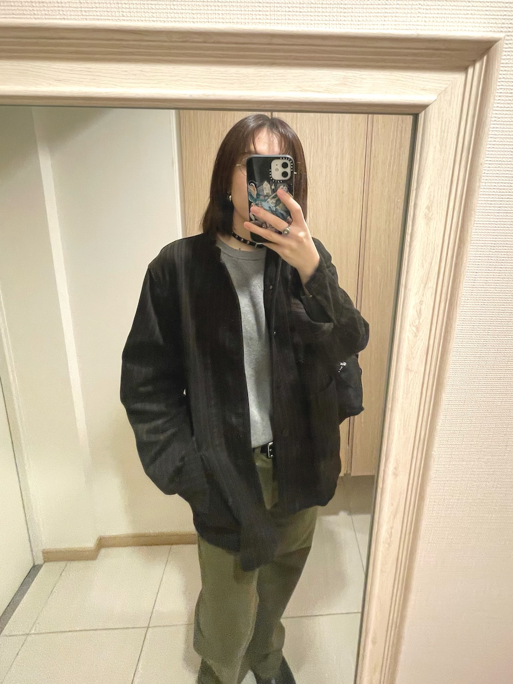 グレー系のトップス、ブラウン系のジャケット/アウター、グリーン系のパンツを着用したレディースの秋コーディネートの2枚目の写真