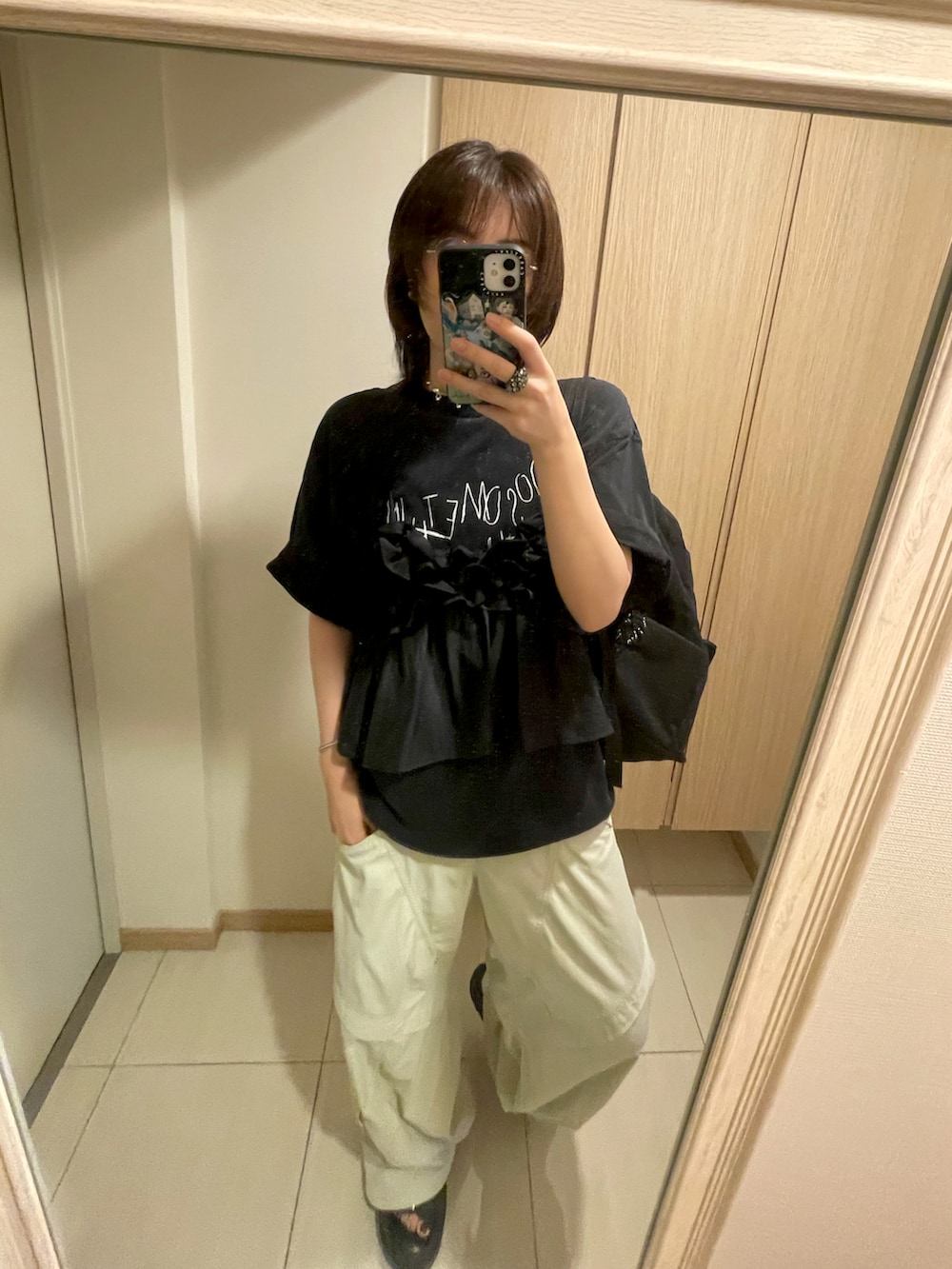 ブラック系のキャミソール、ホワイト系のカーゴパンツ、ブラック系のサンダルを着用したレディースの秋コーディネートの3枚目の写真