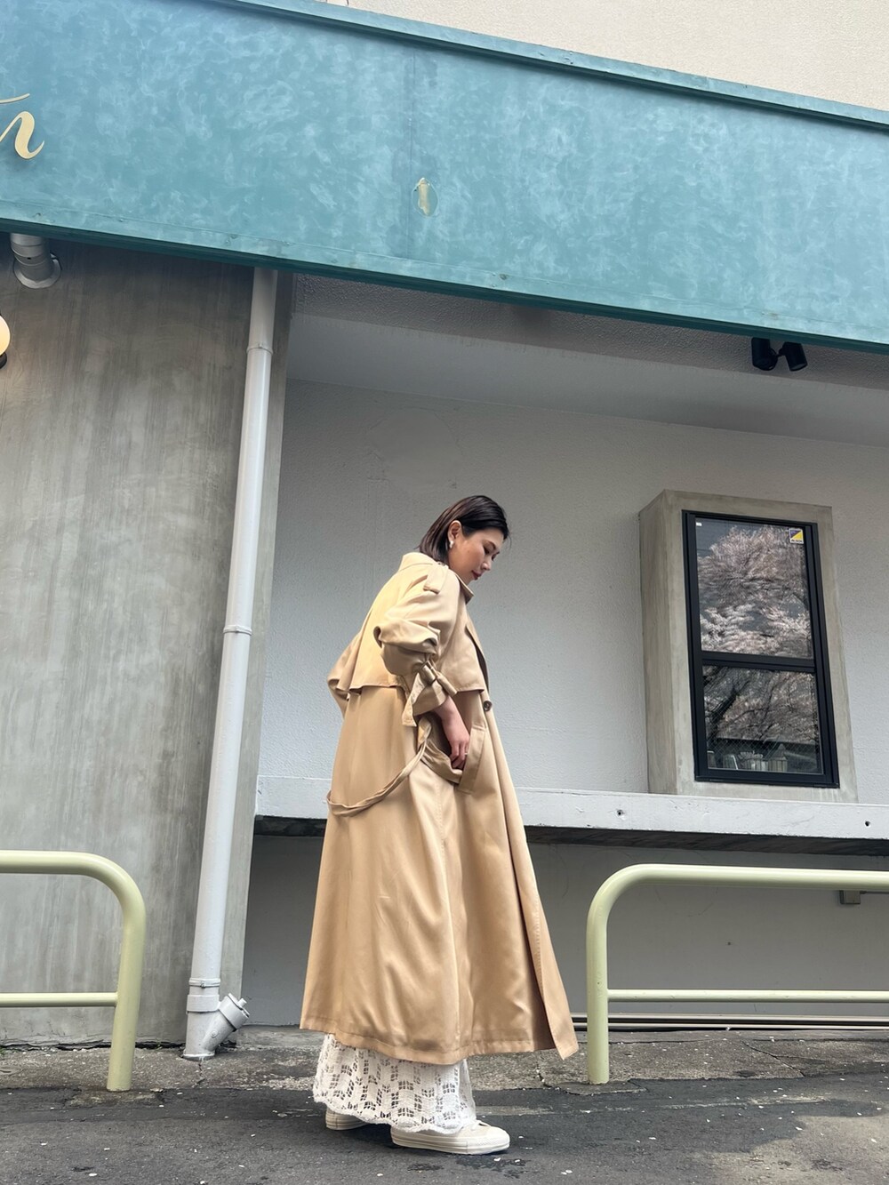 ベージュ系のトレンチコート、ホワイト系のTシャツ/カットソー、ホワイト系のスカートを着用したレディースの春コーディネートの2枚目の写真