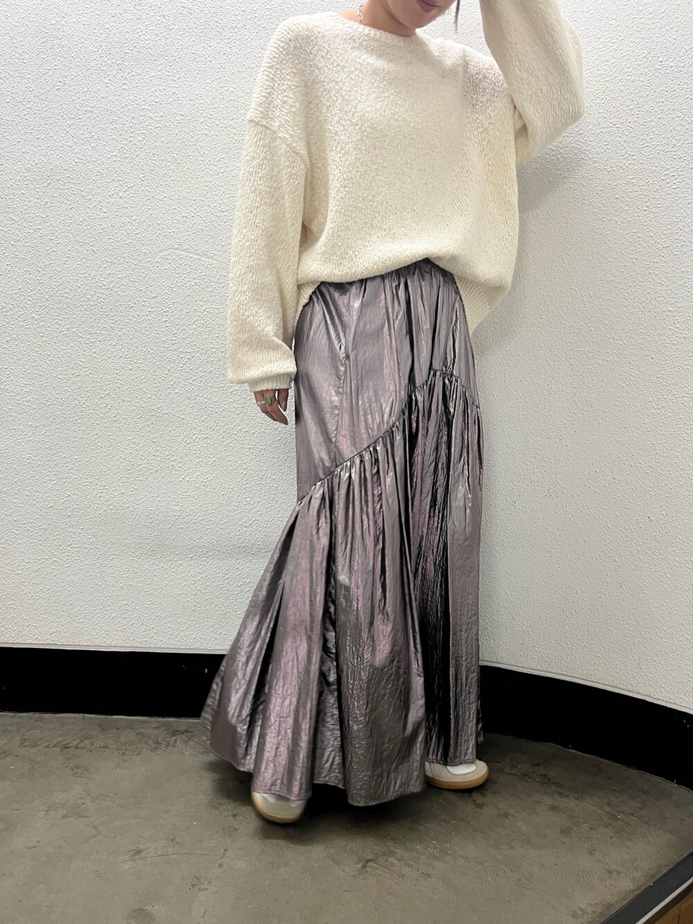 ホワイト系のニット/セーター、シルバー系のスカート、ベージュ系のキャップを着用したレディースの冬コーディネートの3枚目の写真