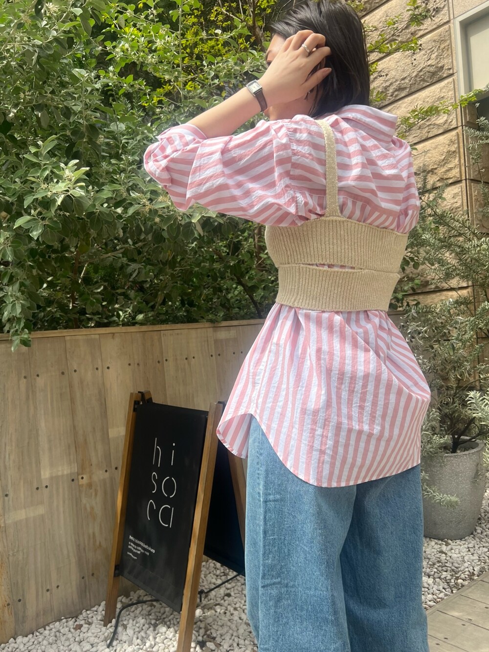 ピンク系のシャツ/ブラウス、ホワイト系のニット/セーター、ブルー系のデニムパンツを着用したレディースの春コーディネートの3枚目の写真