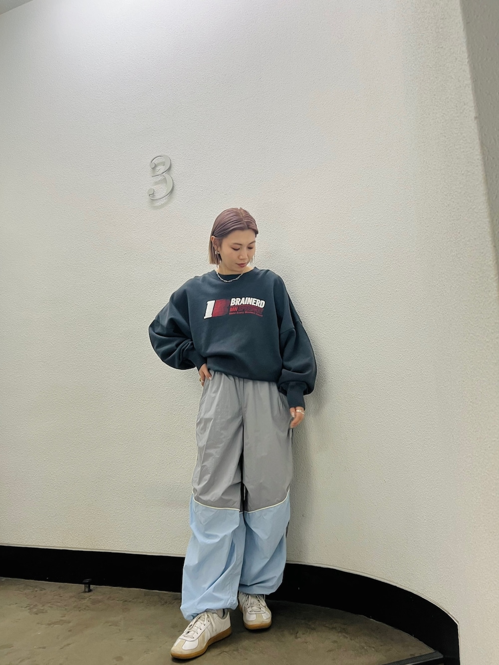 グレー系のスウェット、ブルー系のその他パンツを着用したレディースの冬コーディネートの2枚目の写真