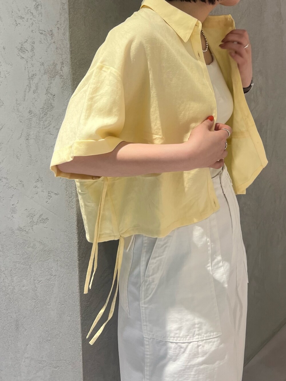 イエロー系のシャツ/ブラウス、ホワイト系のキャミソール、ホワイト系のその他パンツを着用したレディースの春コーディネートの5枚目の写真