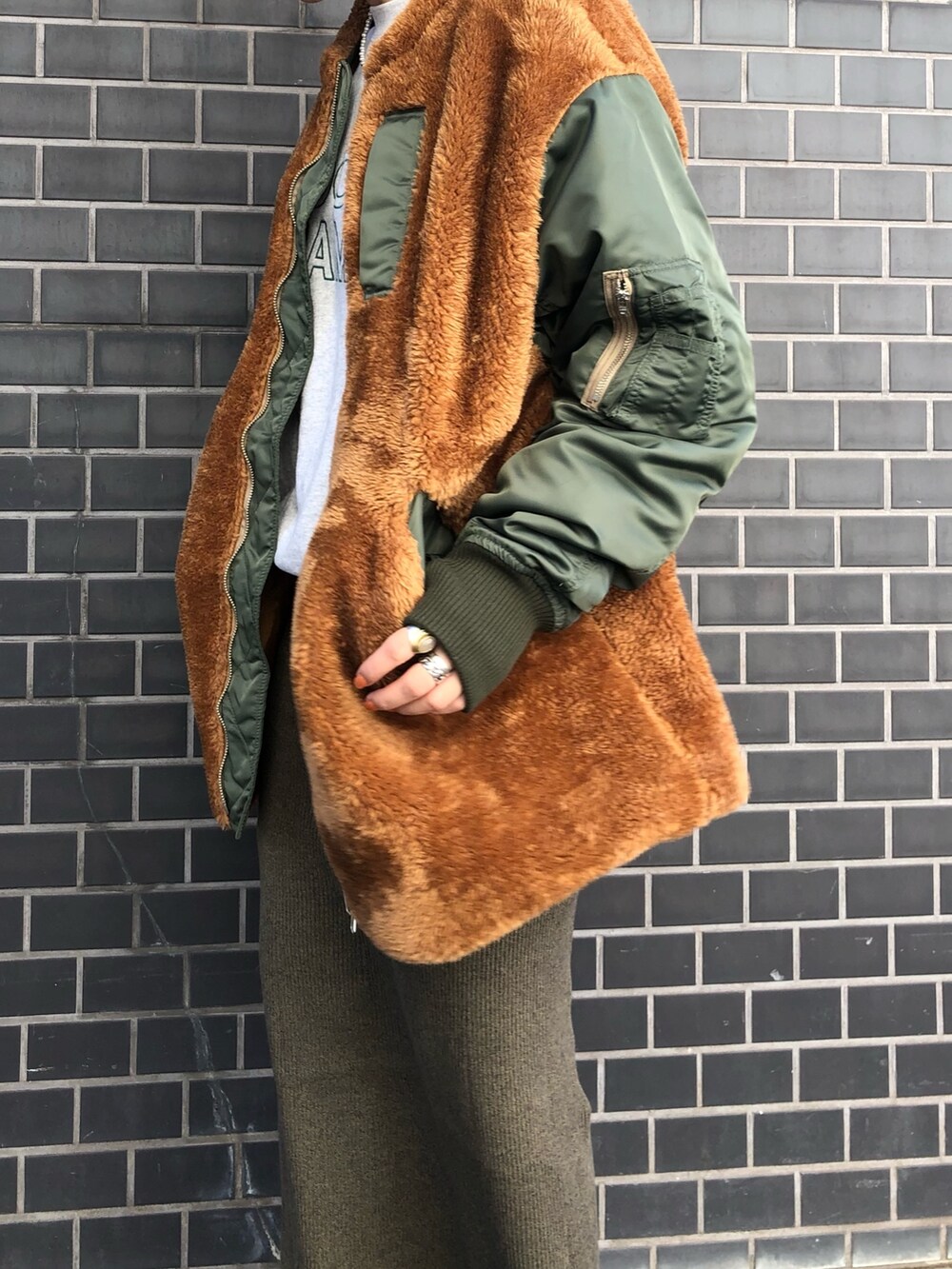 グリーン系のブルゾン、グレー系のスウェット、グリーン系のスカートを着用したレディースの秋コーディネートの3枚目の写真