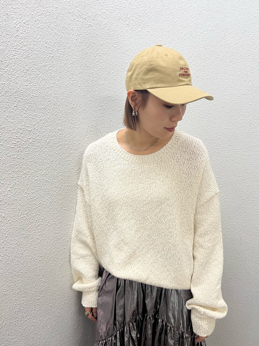 ホワイト系のニット/セーター、シルバー系のスカート、ベージュ系のキャップを着用したレディースの冬コーディネートの5枚目の写真