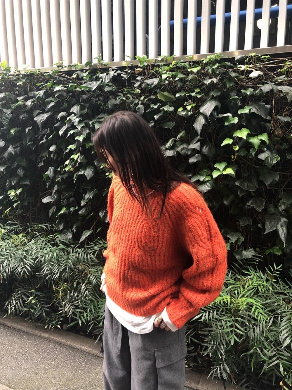 ホワイト系のTシャツ/カットソー、グレー系のカーゴパンツ、オレンジ系のニット/セーターを着用したレディースの秋コーディネートの3枚目の写真