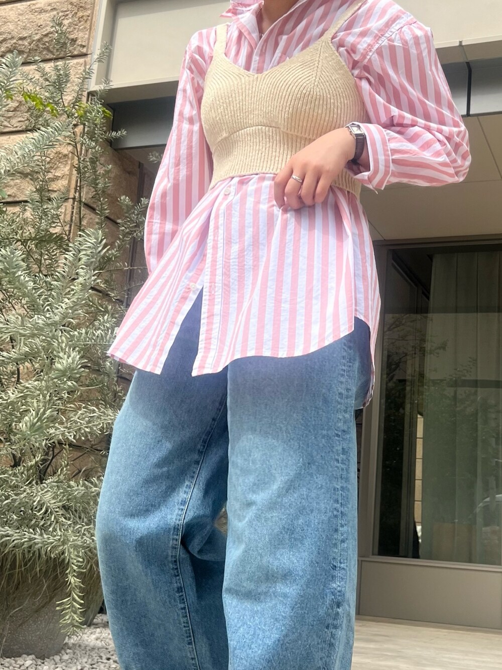 ピンク系のシャツ/ブラウス、ホワイト系のニット/セーター、ブルー系のデニムパンツを着用したレディースの春コーディネートの4枚目の写真