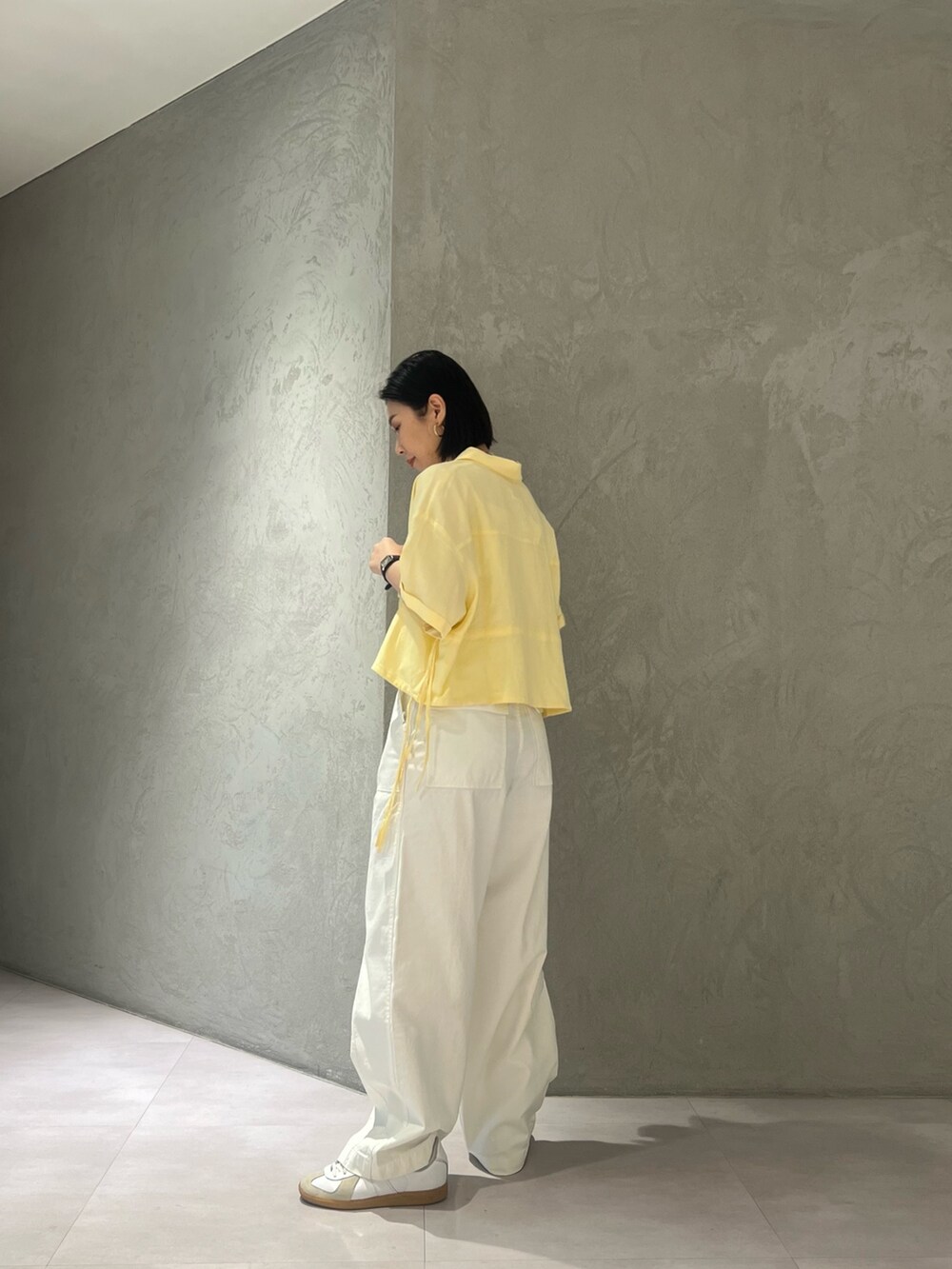 イエロー系のシャツ/ブラウス、ホワイト系のキャミソール、ホワイト系のその他パンツを着用したレディースの春コーディネートの3枚目の写真
