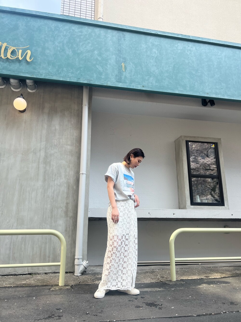 ベージュ系のトレンチコート、ホワイト系のTシャツ/カットソー、ホワイト系のスカートを着用したレディースの春コーディネートの5枚目の写真