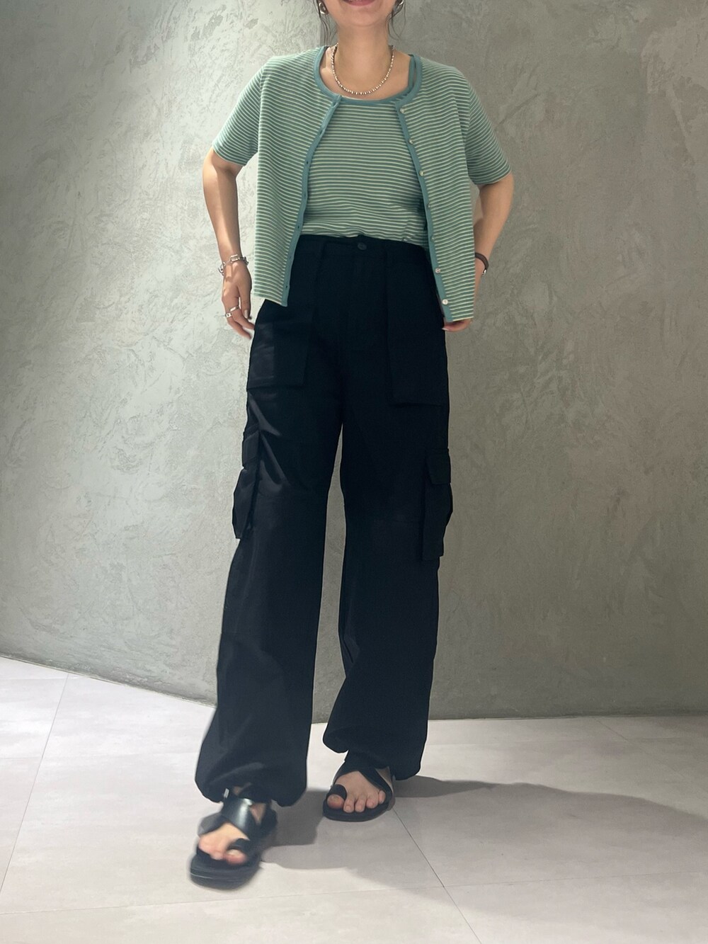ブラック系のカーゴパンツ、イエロー系のキャミソールを着用したレディースの夏コーディネートの2枚目の写真