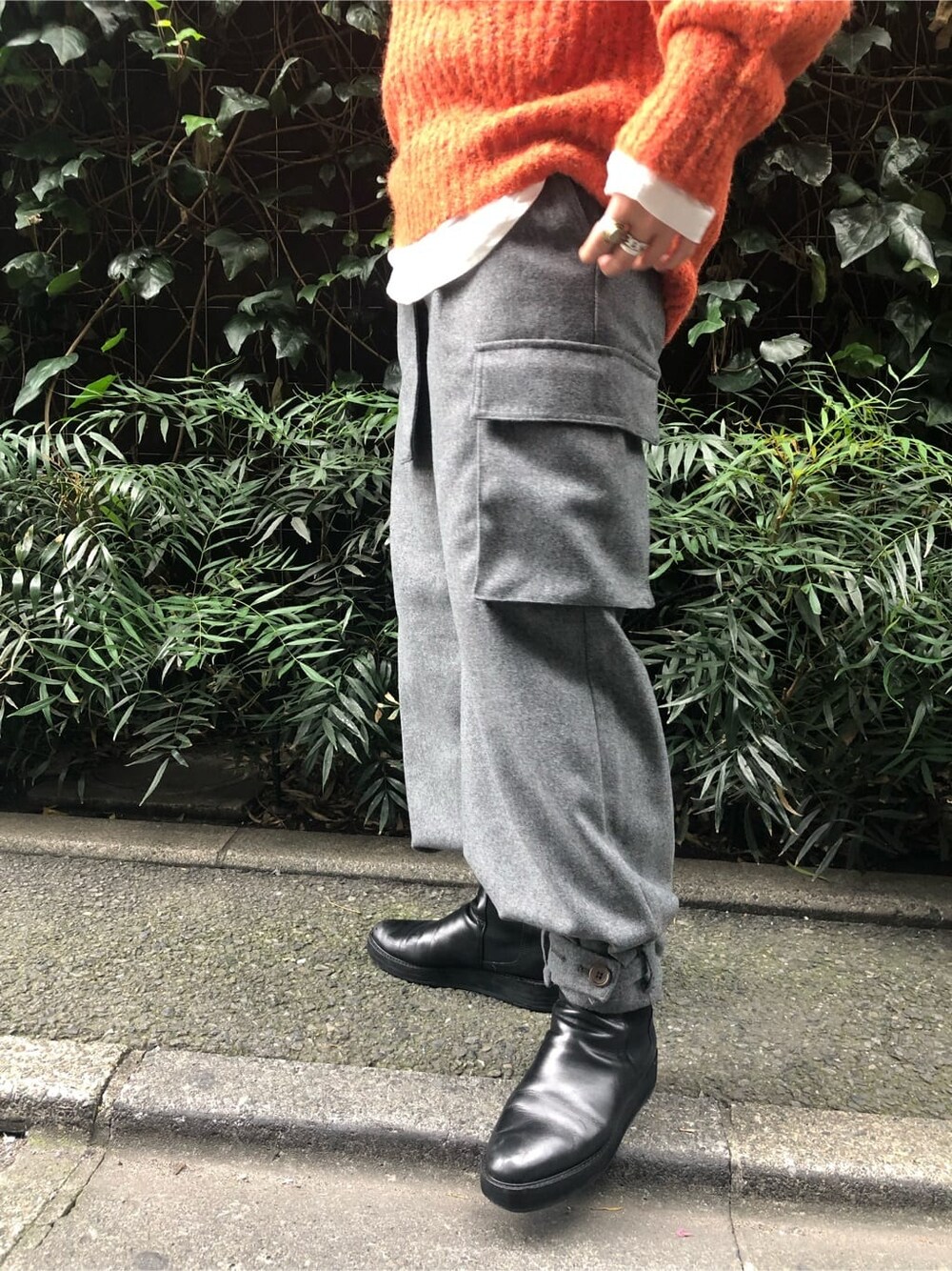 ホワイト系のTシャツ/カットソー、グレー系のカーゴパンツ、オレンジ系のニット/セーターを着用したレディースの秋コーディネートの4枚目の写真