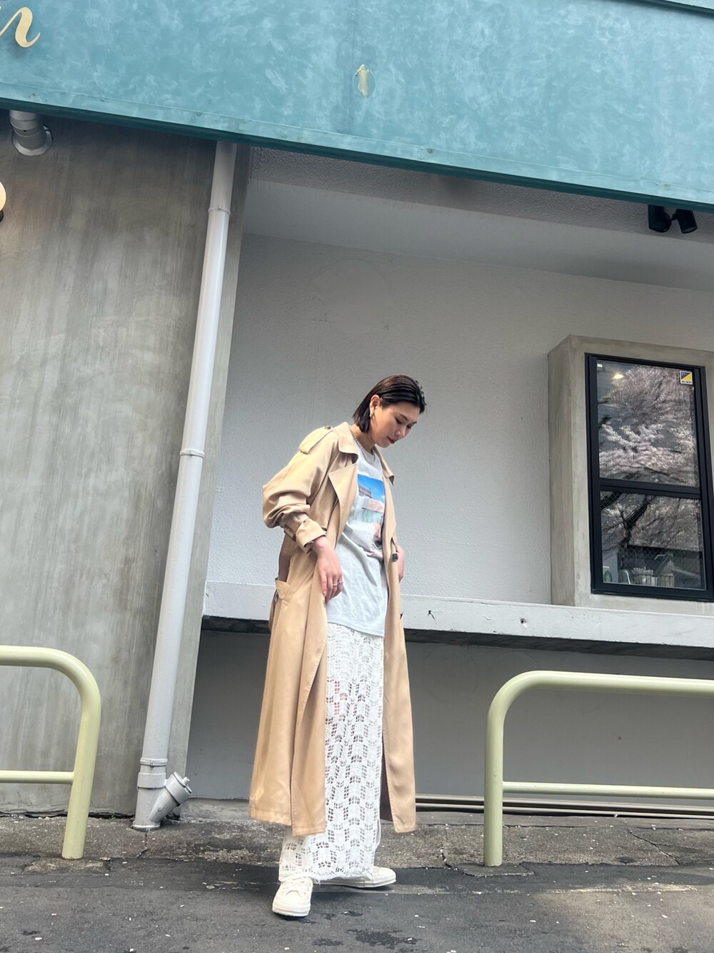 ベージュ系のトレンチコート、ホワイト系のTシャツ/カットソー、ホワイト系のスカートを着用したレディースの春コーディネートの4枚目の写真