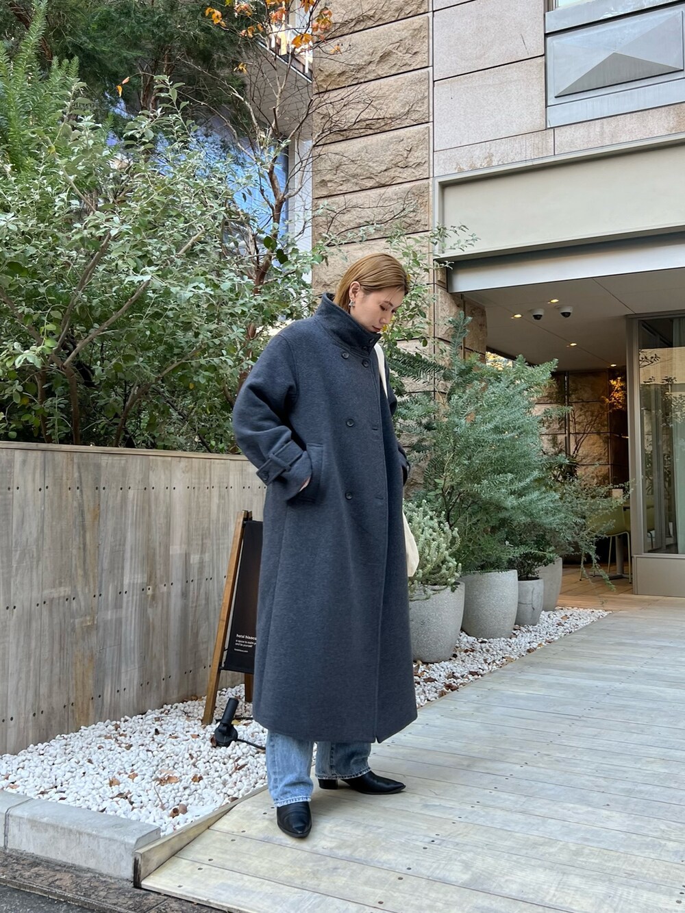 グレー系のその他アウター、ブルー系のデニムパンツ、ブラック系のブーツを着用したレディースの冬コーディネートの2枚目の写真