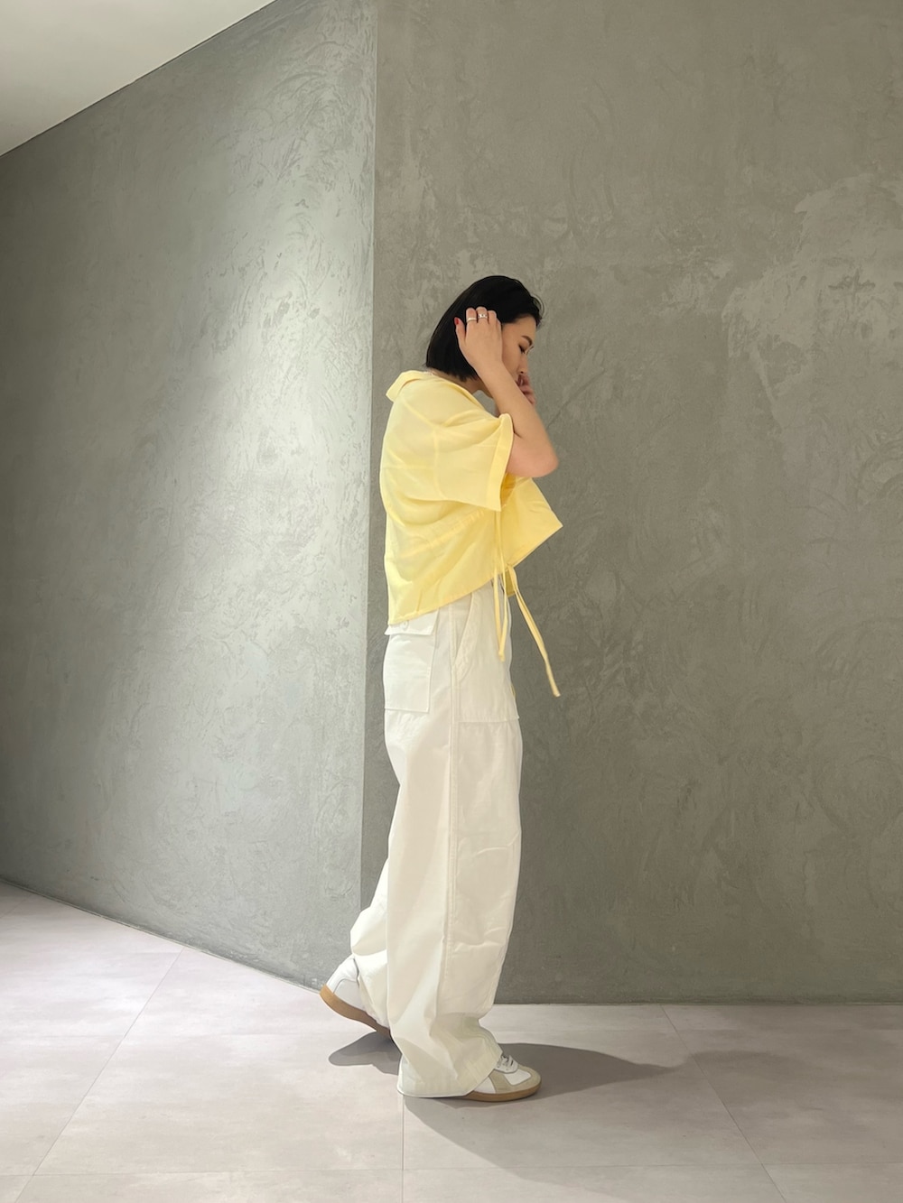 イエロー系のシャツ/ブラウス、ホワイト系のキャミソール、ホワイト系のその他パンツを着用したレディースの春コーディネートの4枚目の写真