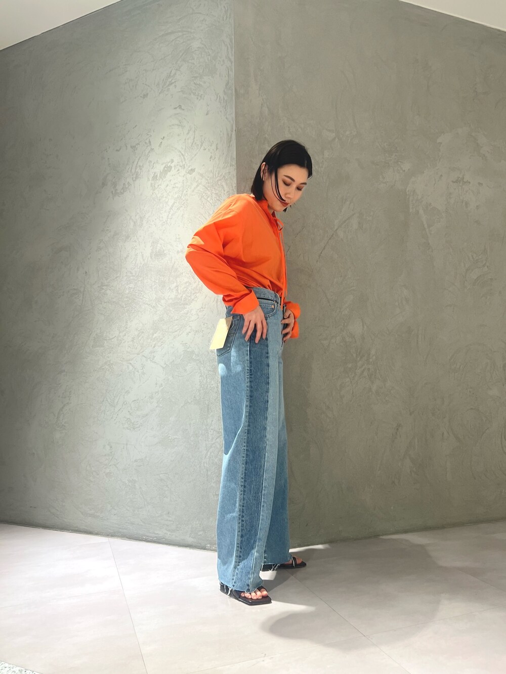 ブラック系のシャツ/ブラウス、ブルー系のデニムパンツ、ホワイト系のサンダルを着用したレディースの春コーディネートの2枚目の写真