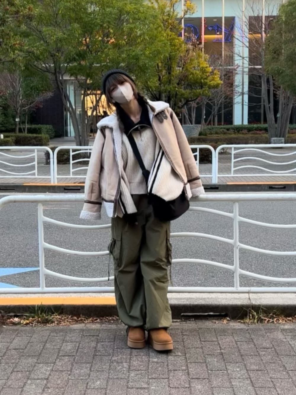 ホワイト系のニット/セーター、グリーン系のカーゴパンツ、ブラウン系のブーツを着用したレディースの冬コーディネートの3枚目の写真