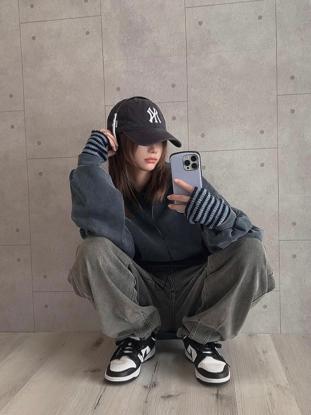 ブルー系のパーカー、グレー系のパンツ、ブラック系のスニーカーを着用したレディースの秋コーディネートの2枚目の写真