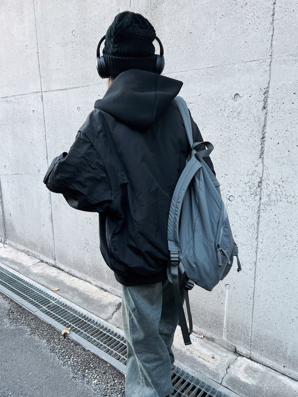 ブラック系のMA-1、グレー系のバックパック/リュック、ブルー系のデニムパンツを着用したレディースの冬コーディネートの2枚目の写真