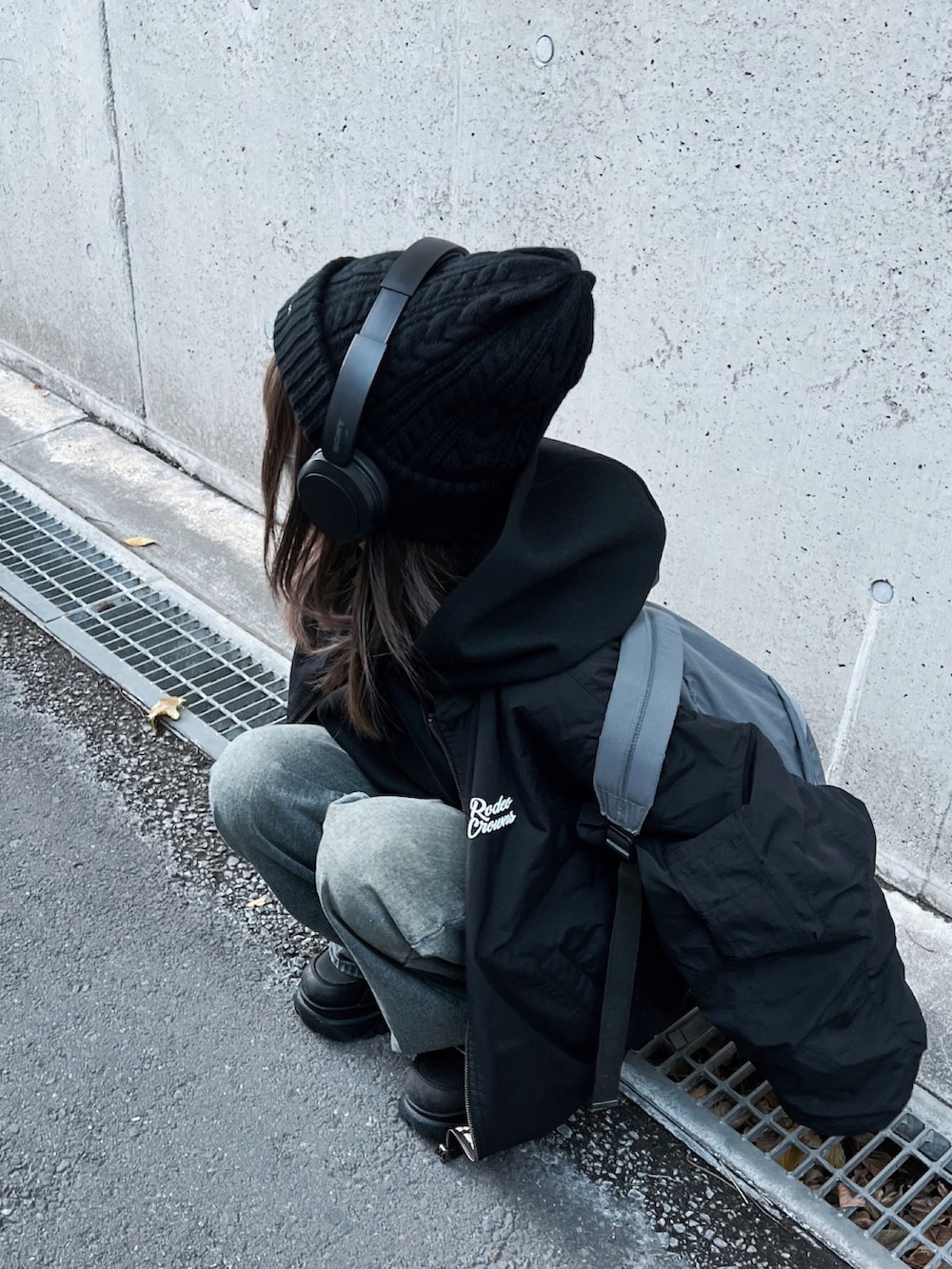 ブラック系のMA-1、グレー系のバックパック/リュック、ブルー系のデニムパンツを着用したレディースの冬コーディネートの3枚目の写真