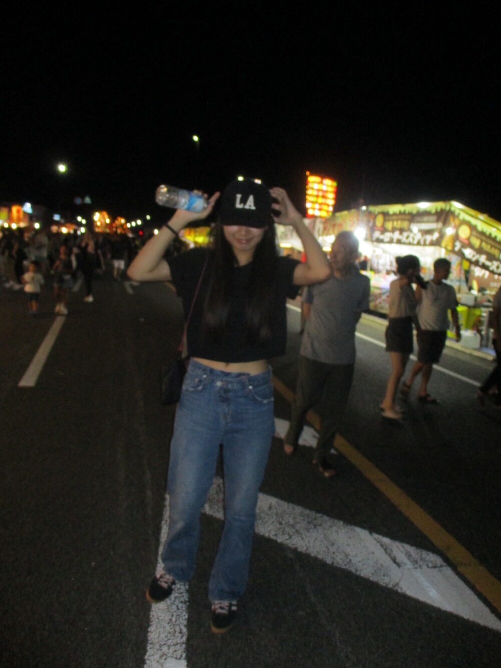 ブラック系のトップス、ブルー系のデニムパンツ、ブラック系のバッグを着用したレディースの秋コーディネートの3枚目の写真