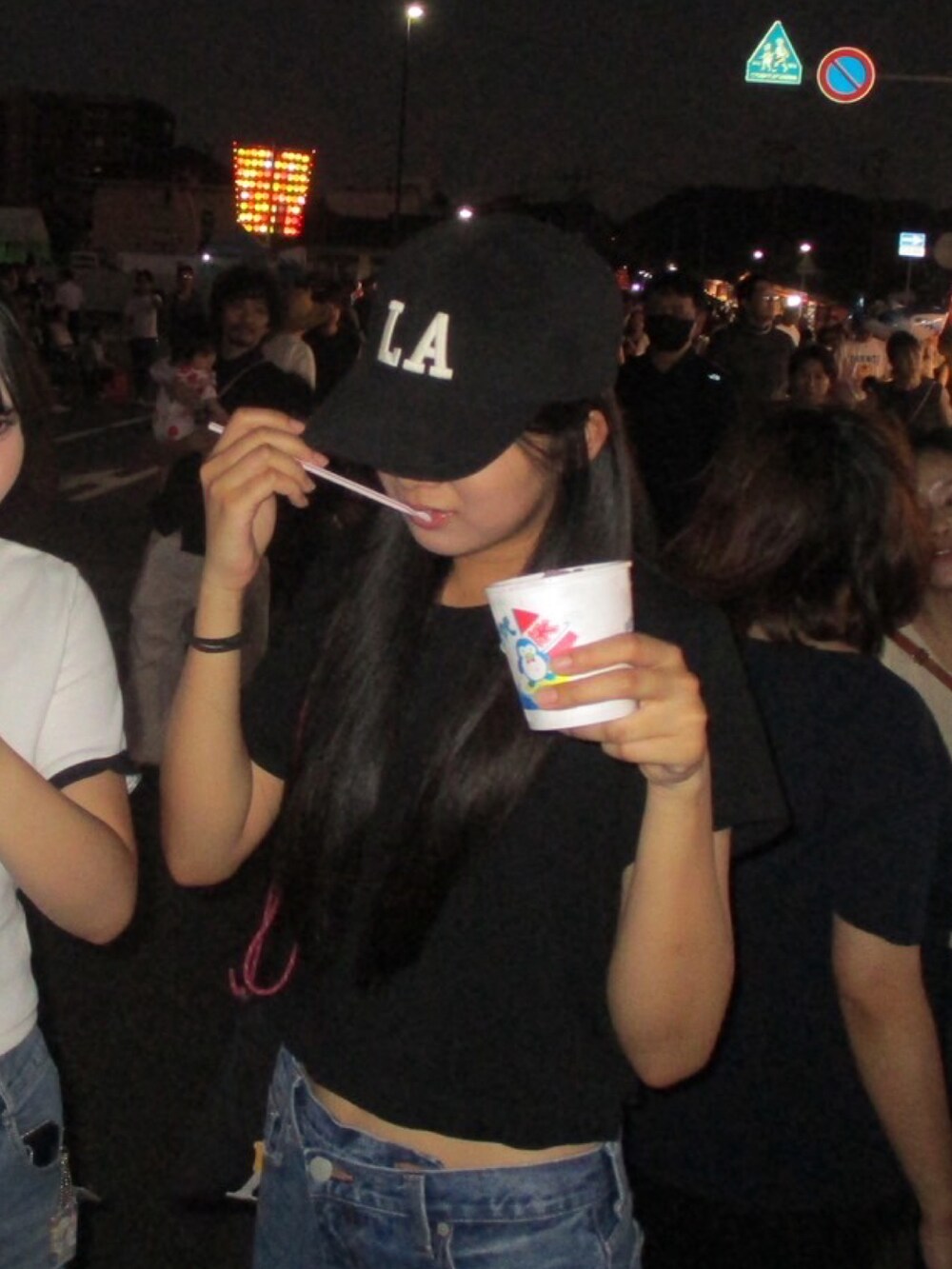 ブラック系のトップス、ブルー系のデニムパンツ、ブラック系のバッグを着用したレディースの秋コーディネートの2枚目の写真