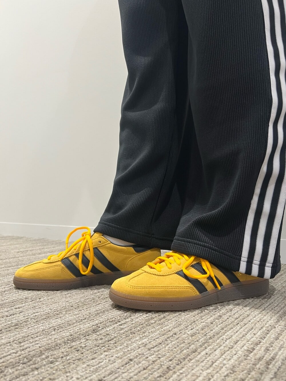 ブラック系のスウェットパンツ、ブラウン系のバッグ、ホワイト系のジャージを着用したレディースの秋コーディネートの4枚目の写真